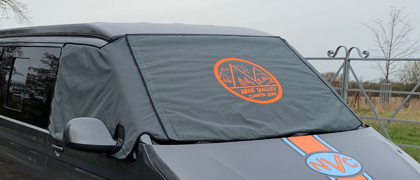 VW T6 Campervan fitted with a Grey Thermal wrap around windscreen cover. The screen cover has a printed company logo in orange.