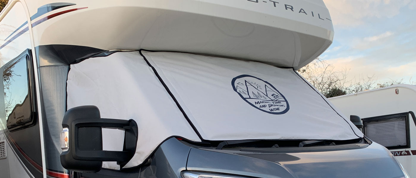 Auto-Trail motorhome fitted with a light Grey Thermal wrap around windscreen cover, the screen cover has a printed Making Time and Drinking Wine logo.